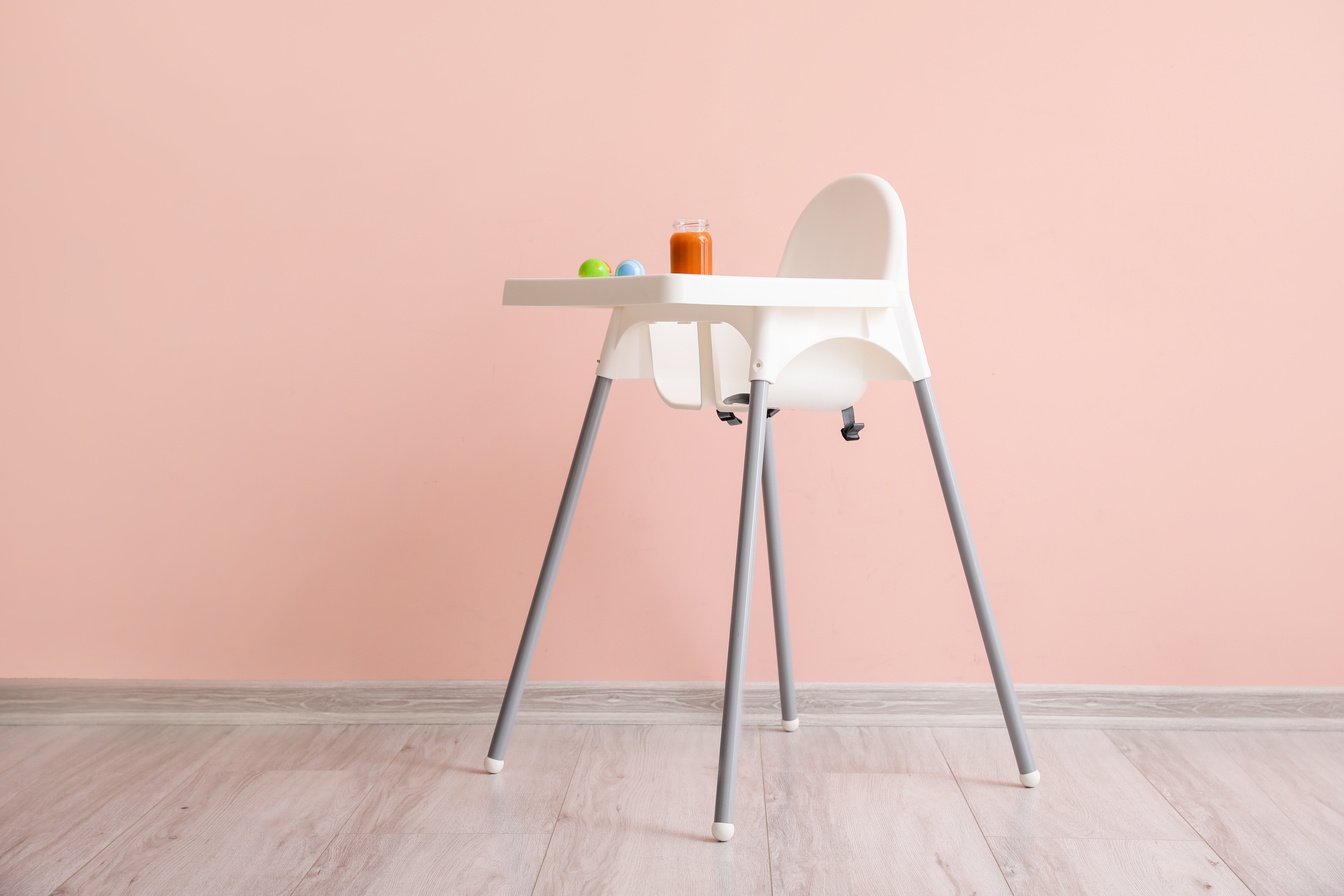 Baby Highchair with Food on Color Background